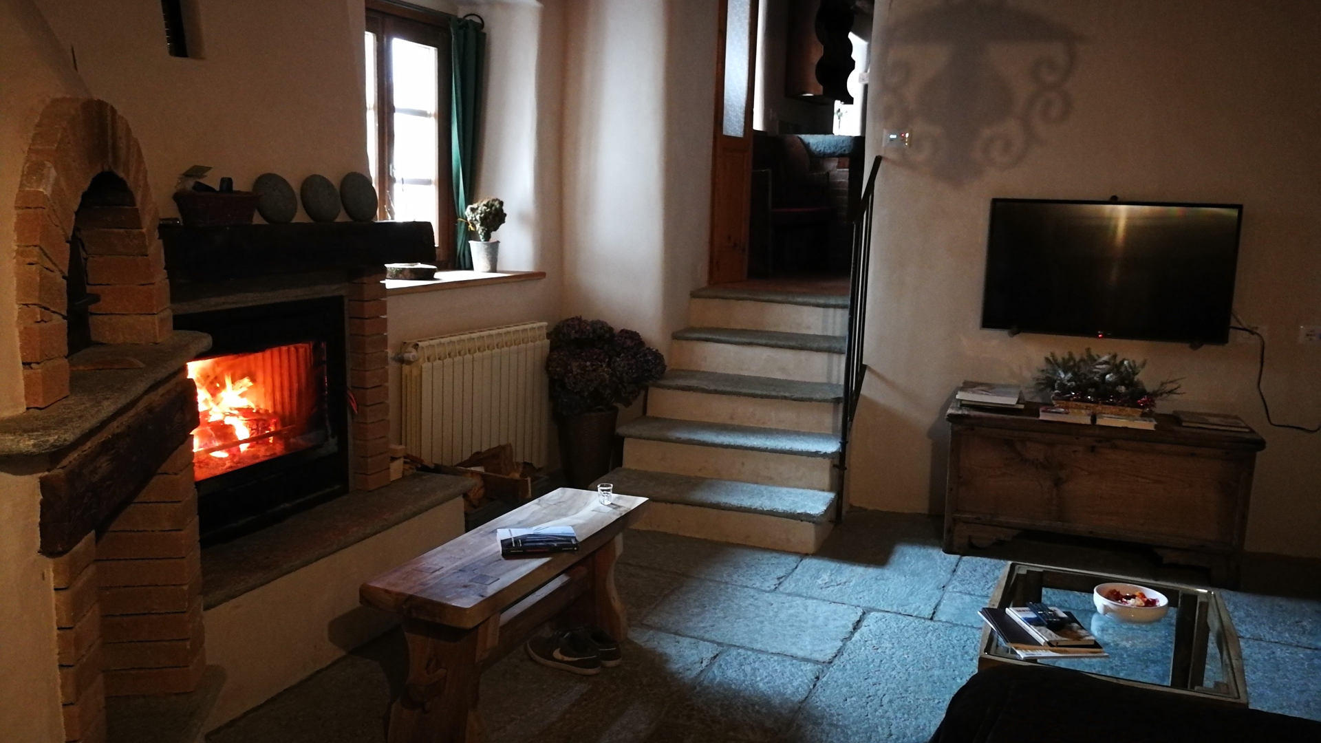 Accogliente soggiorno con camino, divano e tv satellitare